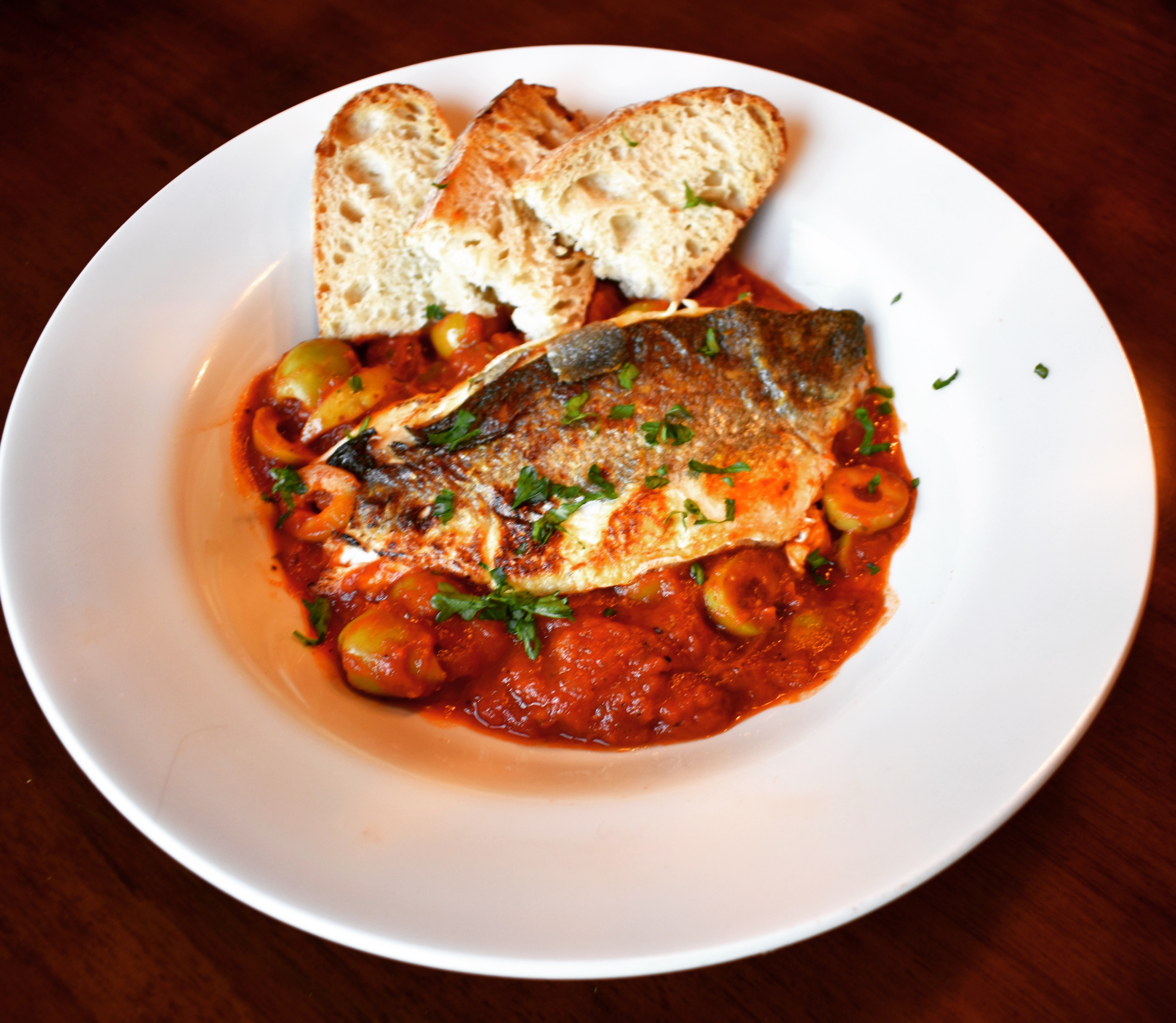 Seabass with preserved lemon, tomato and olive sauce
